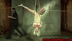 A BDSM slave is flogged, gagged and fucked with a dildo