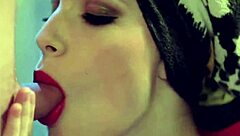 An experienced Asian MILF slowly pleasures her exotic body orally on the bed, showcasing her boobs and panties.