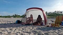 Hot girls give each other hand jobs at the beach