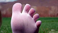 Cute toes in white socks on a spring grass field