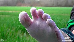 Cute toes in white socks on a spring grass field