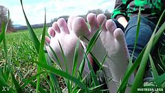 Cute toes in white socks on a spring grass field