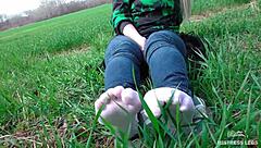 Cute toes in white socks on a spring grass field