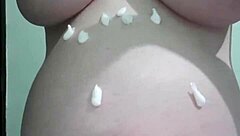 A pregnant woman is being massaged with cream on her belly