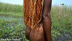 African beauty bathes in the river, caressing her ass