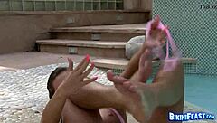 A girl in a bikini is masturbating by the pool, capturing her best moments