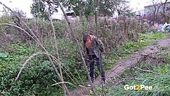 The beautiful girl pees directly in nature