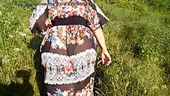 A mature woman is trying on a see-through dress