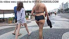 Sexy milf blonde flashes in mini short on Copacabana beach with guys staring