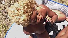 Porsha Carrera straps on big dildo to roughly dick down Nina Rivera's juicy ebony pussy outdoors on beach.