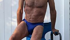 stretching deep in blue briefs on chair october workout thrill