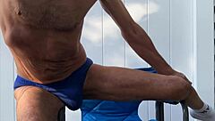 stretching deep in blue briefs on chair october workout thrill
