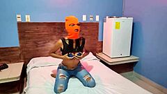 brunette in mask shakes sexy hips naked on halloween hotel bed