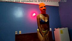 brunette in mask shakes sexy hips naked on halloween hotel bed