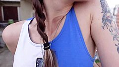 Teen is sucking something on the roof of a building in public