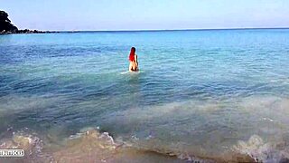 Gola rdečelaska uživa v javnem kopanju na plaži